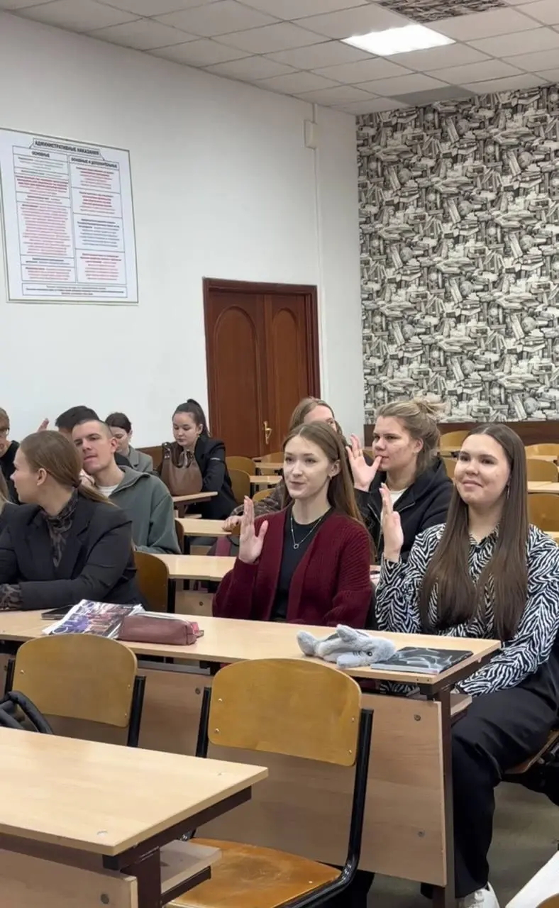 Студенты поднимают руки в аудитории